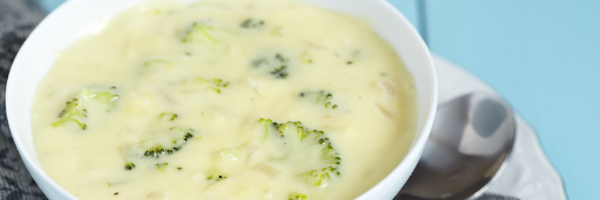 broccoli and cheddar soup in white bowl
